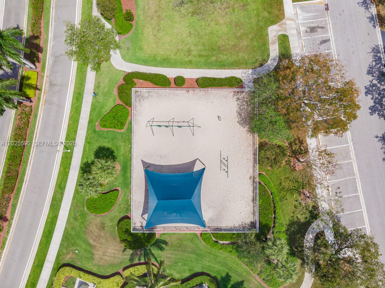 An aerial view shows a fenced playground with a blue shade structure and sandy ground — 2098 Madeira Dr, Weston FL 33327, WESTON, FL