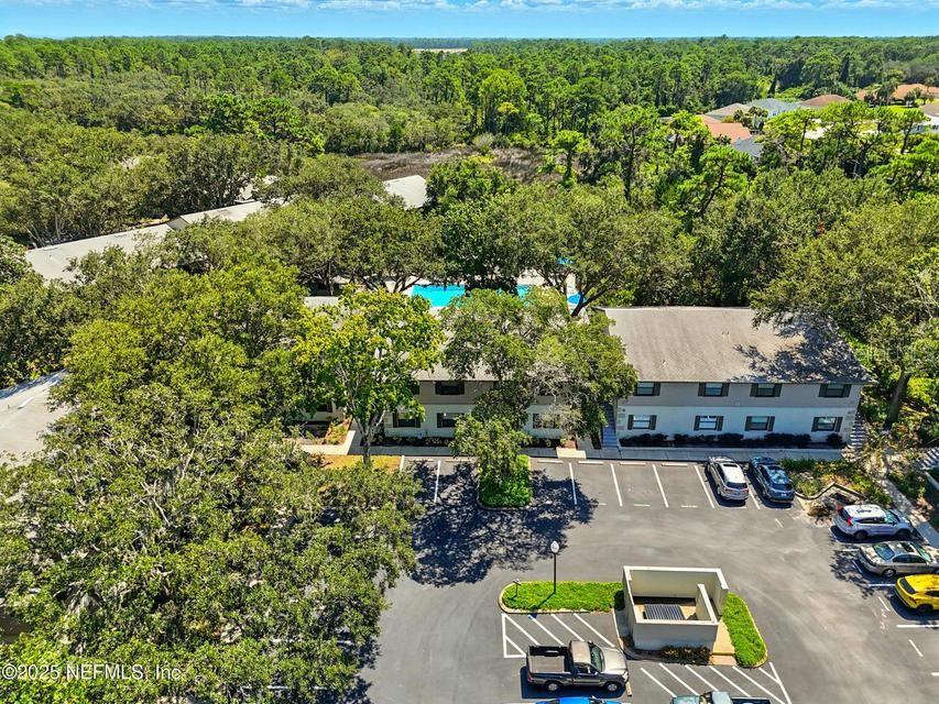 An aerial view shows a multi-story apartment building with a swimming pool and parking lot — 14 NAVARRA COURT UNIT 14, ST AUGUSTINE, FL