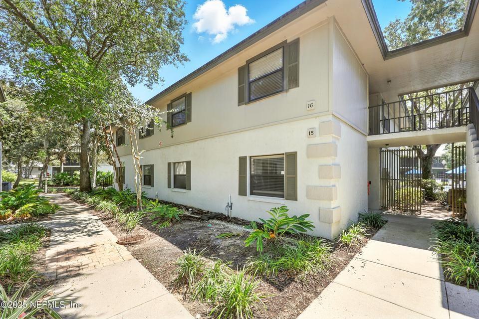 An exterior view of a two-story apartment building with numbered units and a walkway — 14 NAVARRA COURT UNIT 14, ST AUGUSTINE, FL