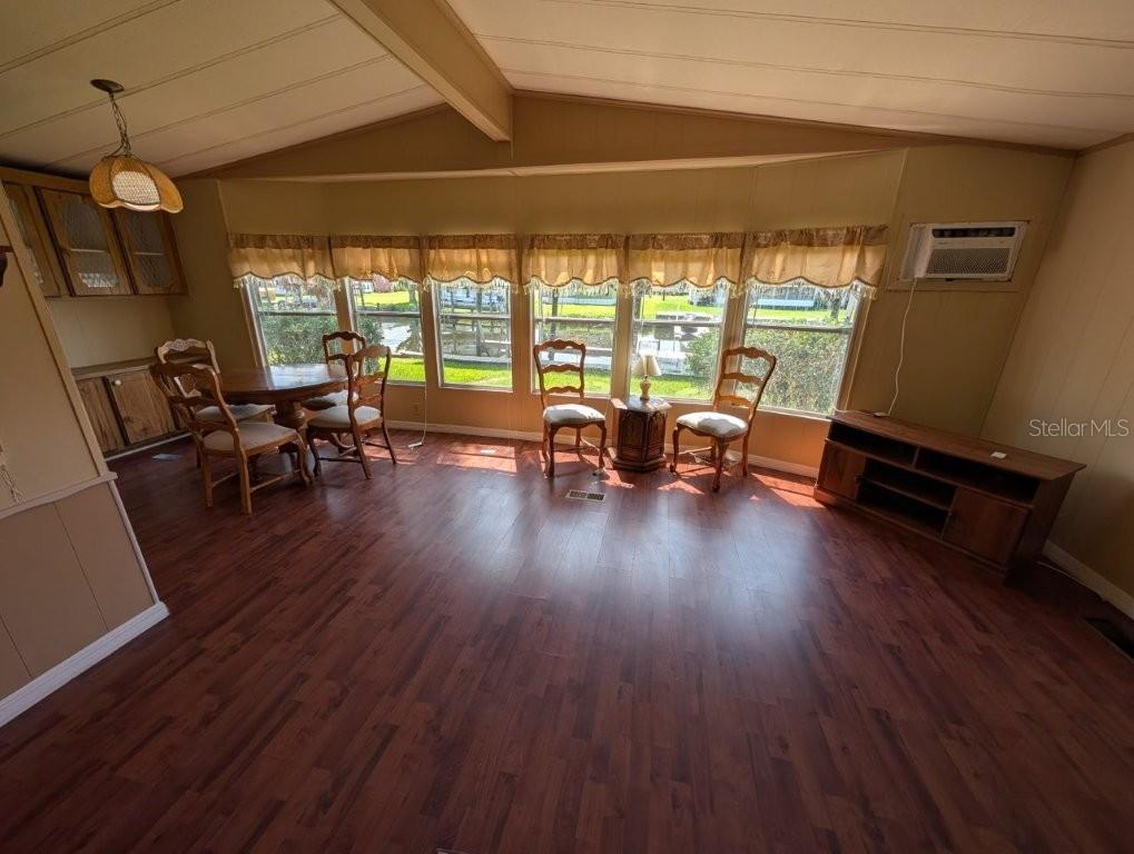 A dining area with wood-look flooring, a table with chairs, and large windows — 154 MOONLITE DRIVE, WELAKA, FL