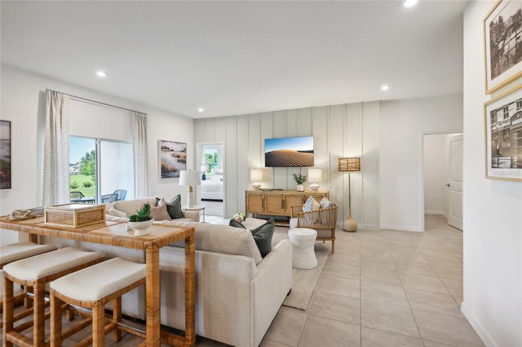 A living room features a sofa, a console table, and a wall with vertical paneling — 12906 CARA COURT, GRAND ISLAND, FL