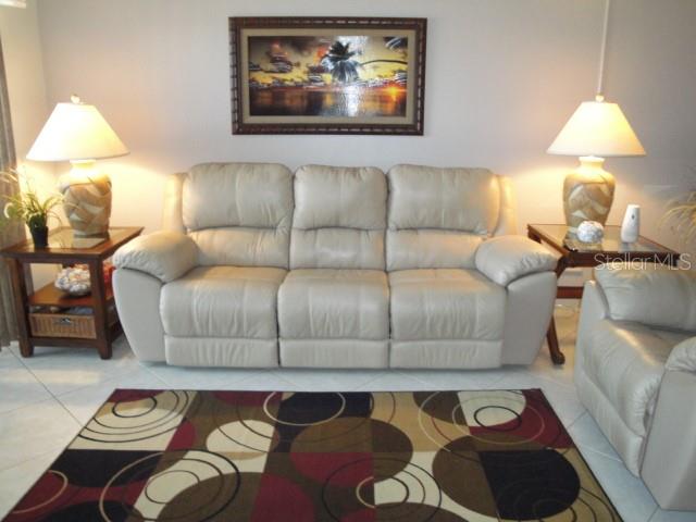 A living room features a beige leather sofa, two side tables with lamps, and a patterned rug — 6365 BAHIA DEL MAR BOULEVARD UNIT 113, ST PETERSBURG, FL