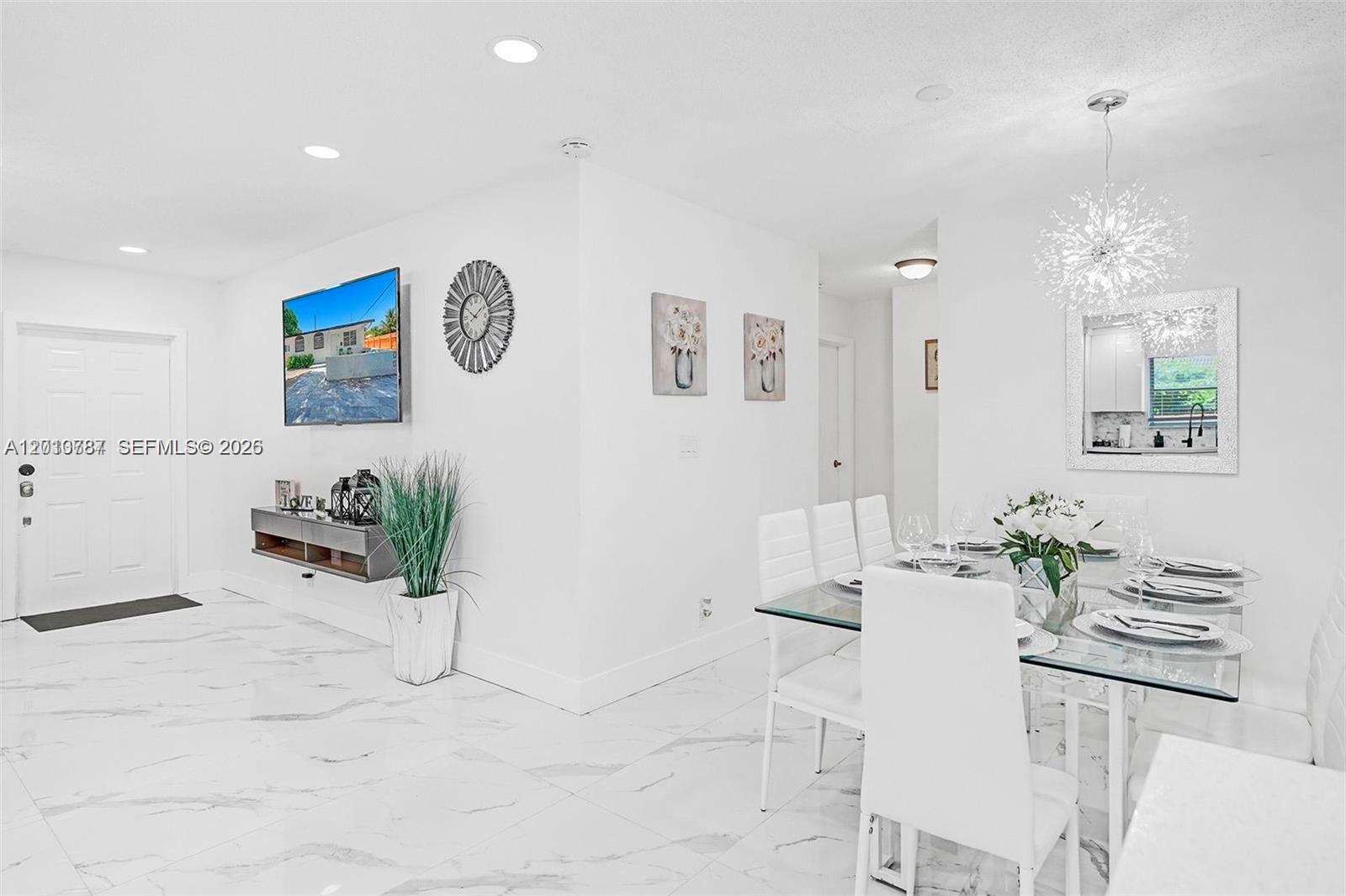 A bright dining area features white walls, marble-style tile flooring, and a glass-topped table — 2338 Fillmore St # 2A, Hollywood FL 33020, HOLLYWOOD, FL