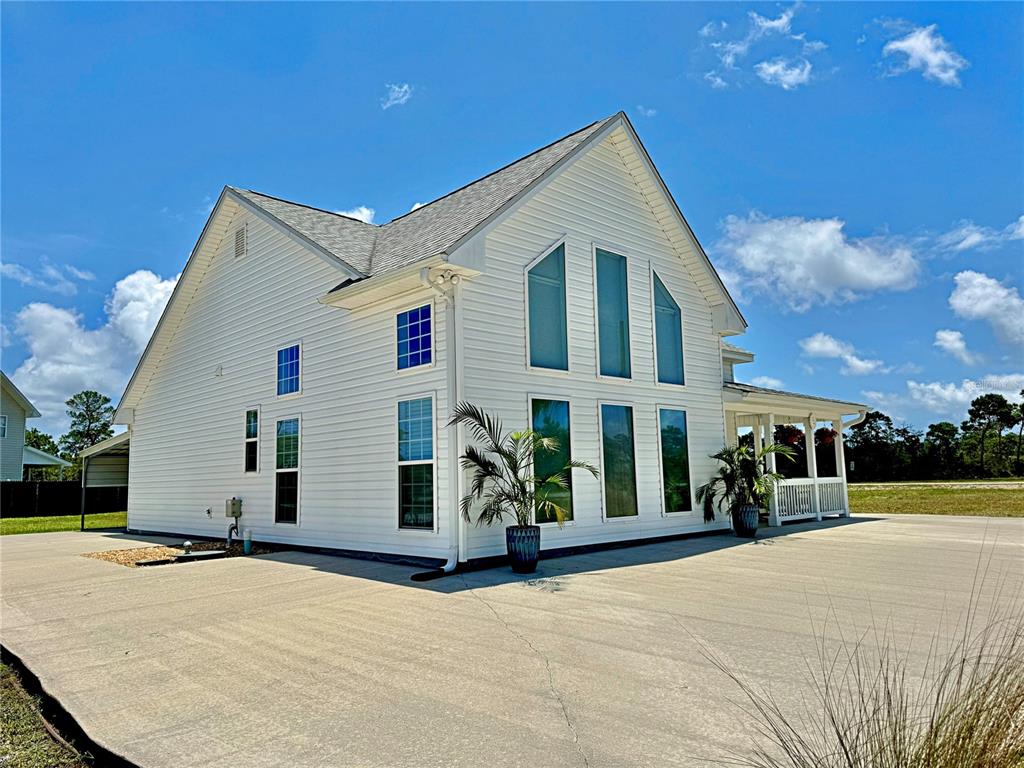 A white two-story house with a large concrete driveway and tall, narrow windows — 260 BLUE HERON DRIVE, EASTPOINT, FL