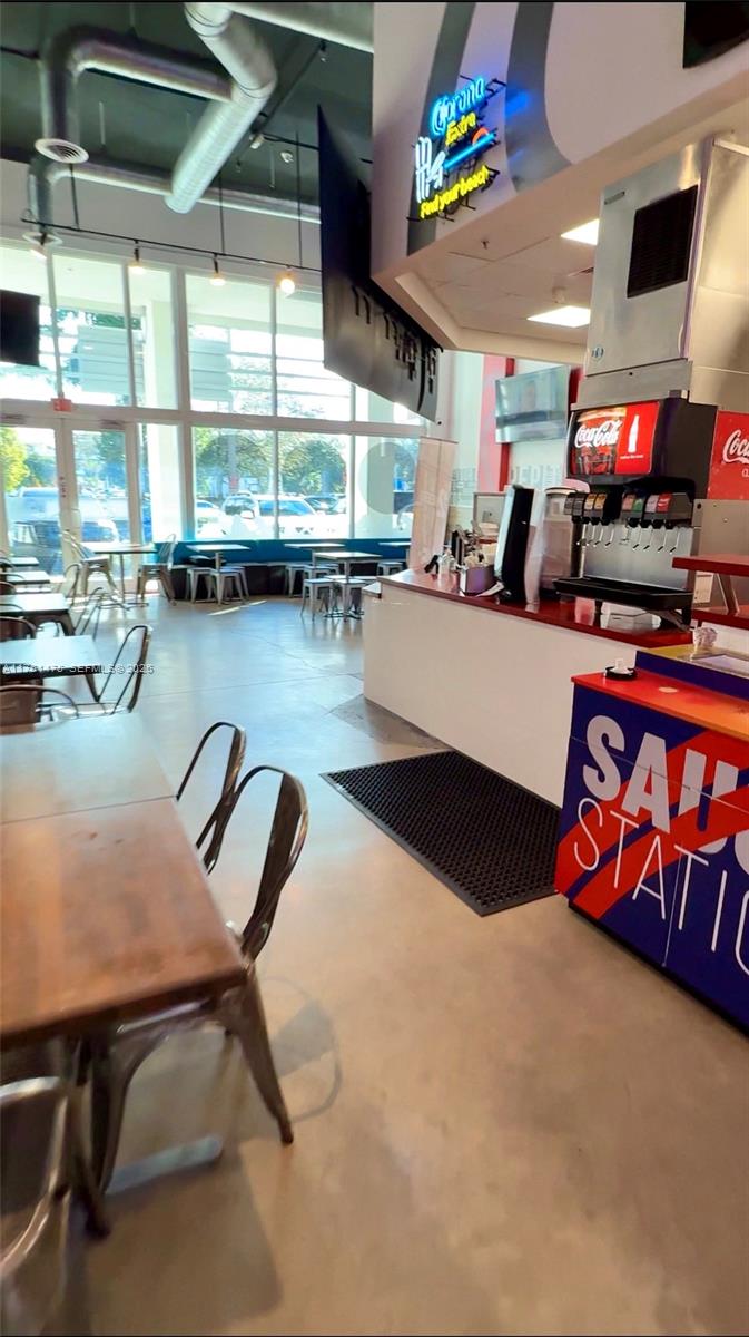 A restaurant interior features a soda fountain, wooden tables, metal chairs, and large windows — 58 ST, Doral FL 33178, DORAL, FL