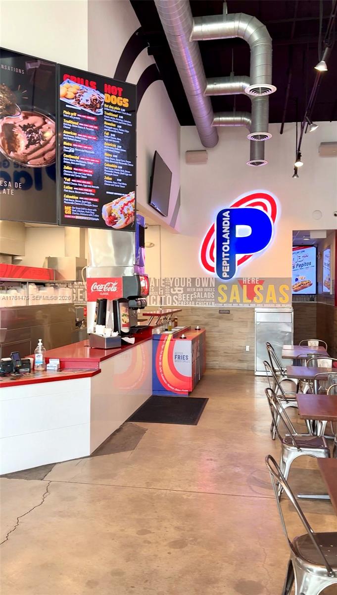 This restaurant interior features a service counter, menu boards, and metal seating tables — 58 ST, Doral FL 33178, DORAL, FL