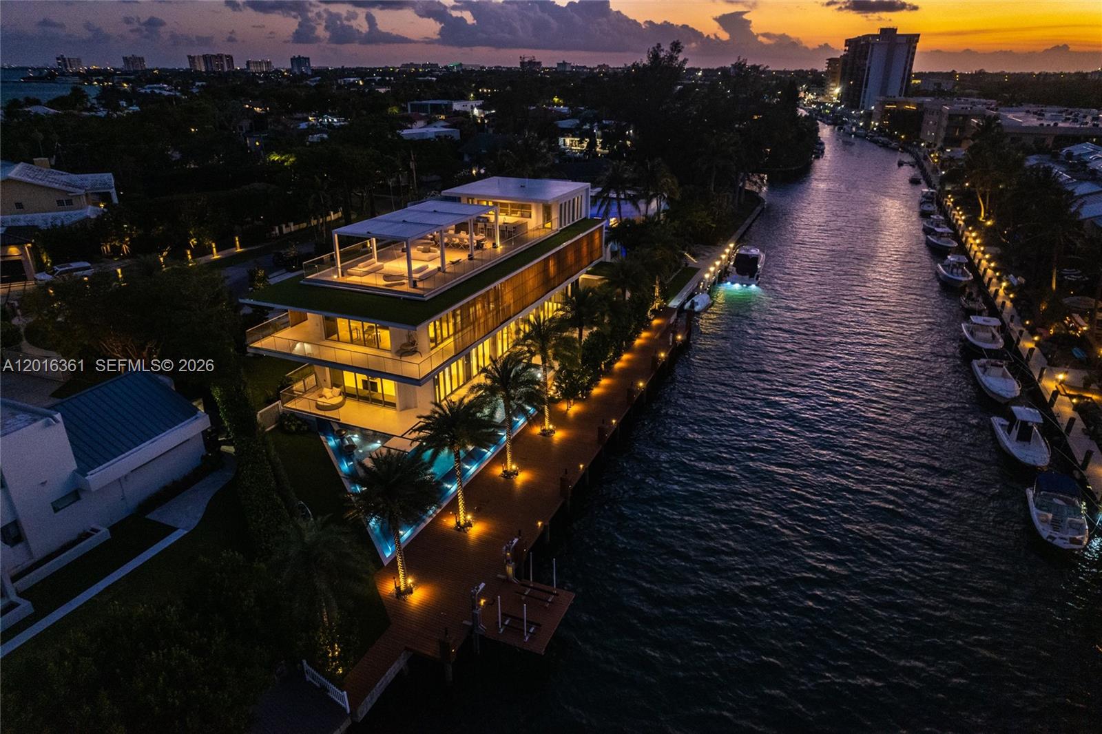 An aerial view of a modern multi-story waterfront home with a rooftop deck and pool — 13390 Biscayne Bay Dr, North Miami FL 33181, NORTH MIAMI, FL