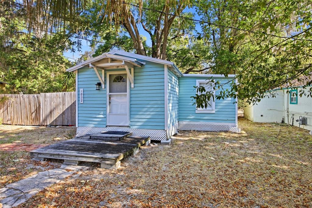 A small, light blue cottage with a wooden deck and white lattice skirting — 1032 NW 40TH AVENUE, GAINESVILLE, FL