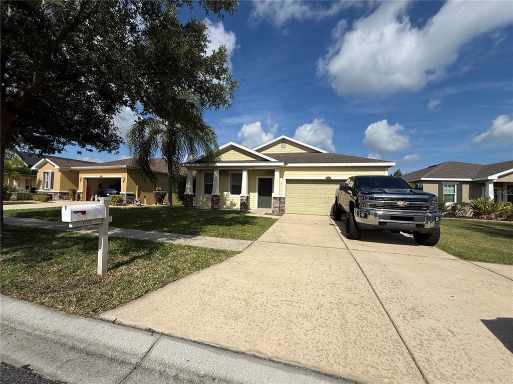 A yellow single-story house with a driveway, a black truck, and a mailbox in front — 1751 BONITA BLUFF COURT, RUSKIN, FL