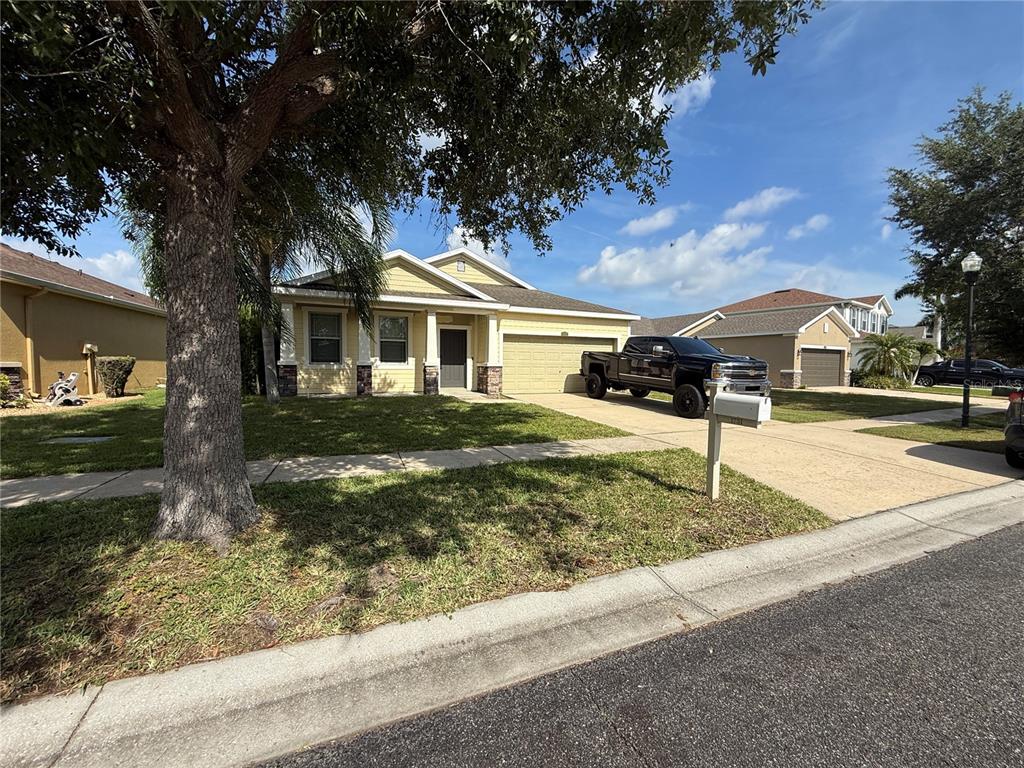 A yellow single-story house with a two-car garage and a large truck in the driveway — 1751 BONITA BLUFF COURT, RUSKIN, FL
