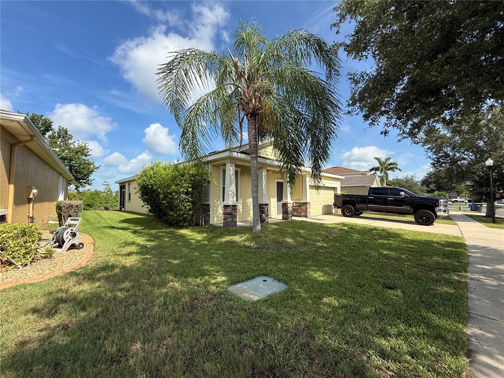 A yellow single-story house with a palm tree in the front yard and a truck — 1751 BONITA BLUFF COURT, RUSKIN, FL