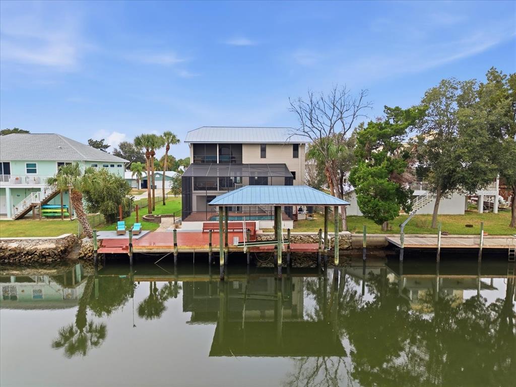 A waterfront house features a covered boat dock, a screened-in pool area, and a wooden deck — 1821 NW 20TH AVENUE, CRYSTAL RIVER, FL