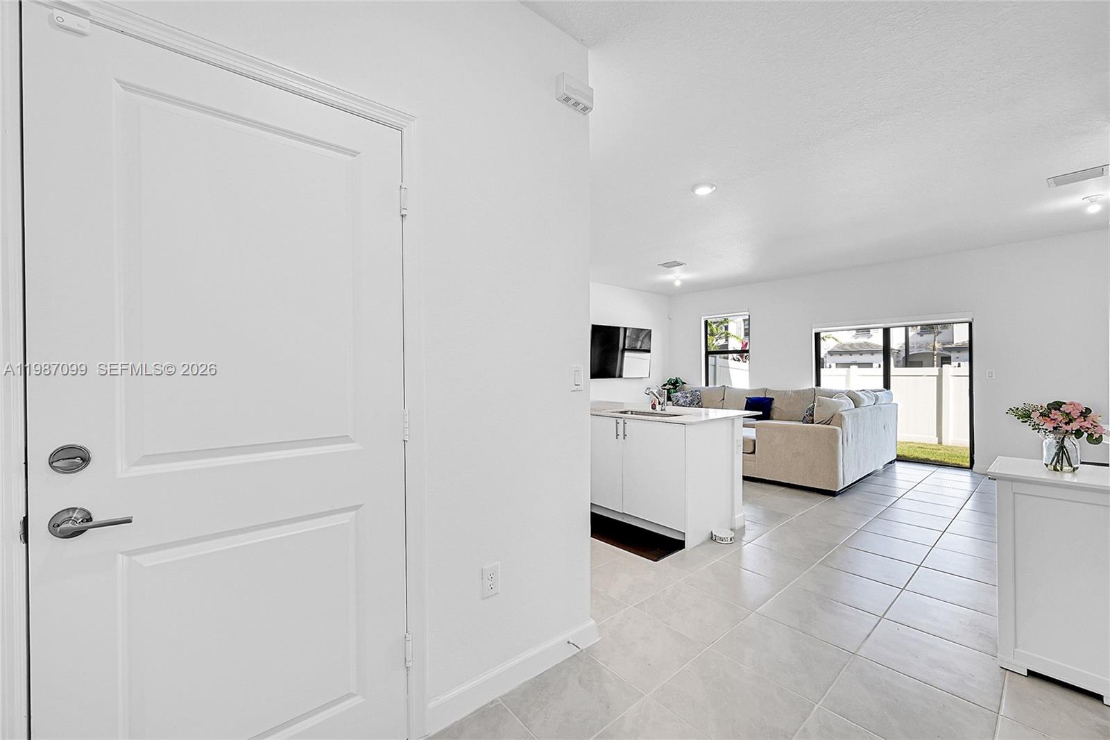 A white interior door opens into a bright living area with a kitchen island — 20357 NW 4th Path, Miami Gardens FL 33169, MIAMI GARDENS, FL