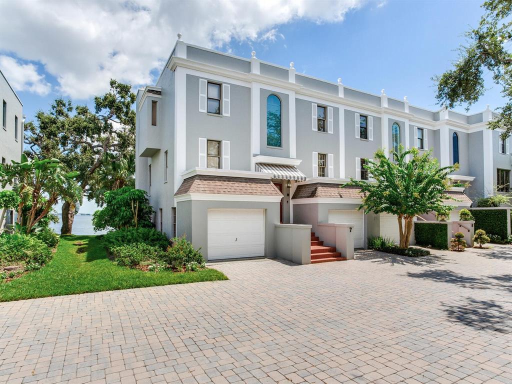 A multi-story gray townhouse with a paved driveway, attached garages, and a waterfront view — 5010 BAYSHORE BOULEVARD UNIT 7, TAMPA, FL