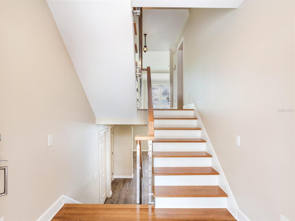 A staircase with wooden treads and white risers leads to an upper floor landing — 5010 BAYSHORE BOULEVARD UNIT 7, TAMPA, FL