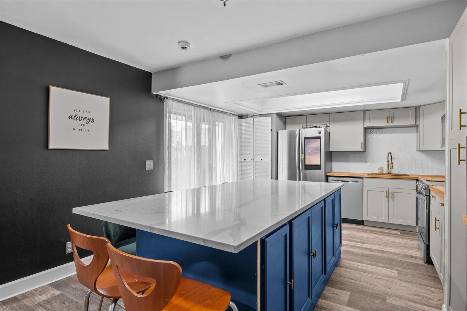 A kitchen features a blue island with a white countertop, grey cabinets, and wood flooring — 1520 Shaker Circle, Wellington FL 33414, WELLINGTON, FL