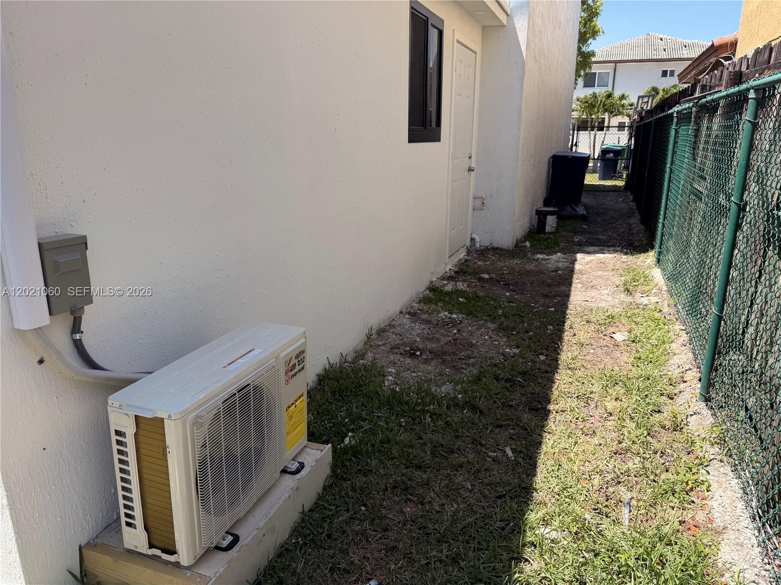 An exterior view shows a white wall with an air conditioning unit and a side door — 16536 SW 54th St # 1, Miami FL 33185, MIAMI, FL
