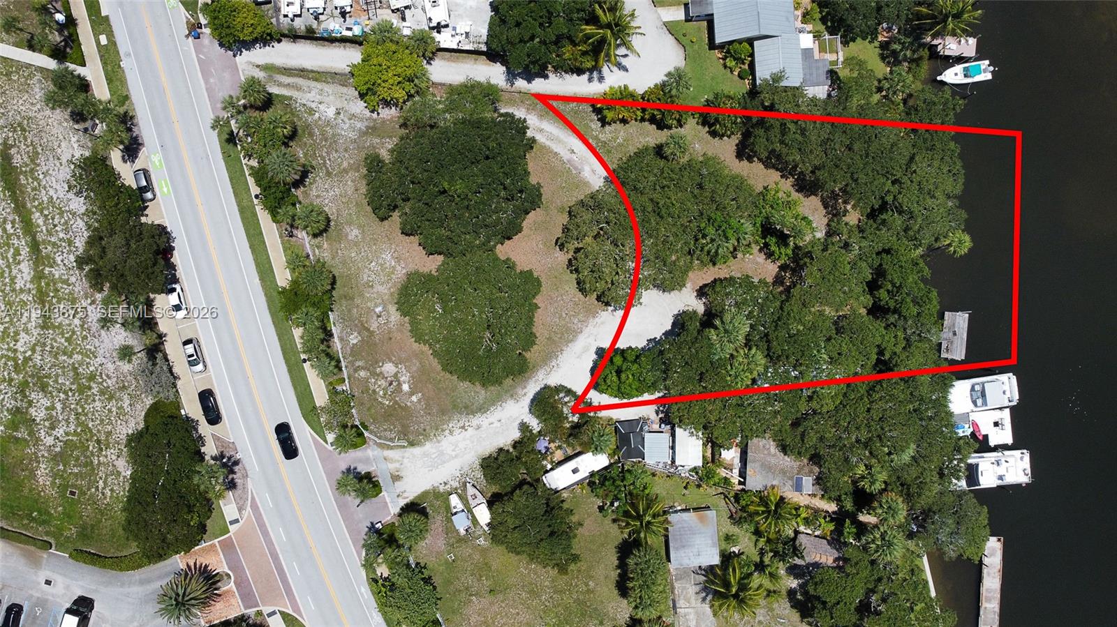 An aerial view shows a wooded waterfront lot outlined in red with private boat docks — 18011 N Highway A1A, Jupiter FL 33477, JUPITER, FL