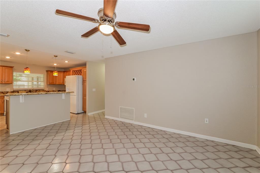 A dining area with tile flooring and a ceiling fan opens into a kitchen — 8873 ASPEN AVENUE, ORLANDO, FL