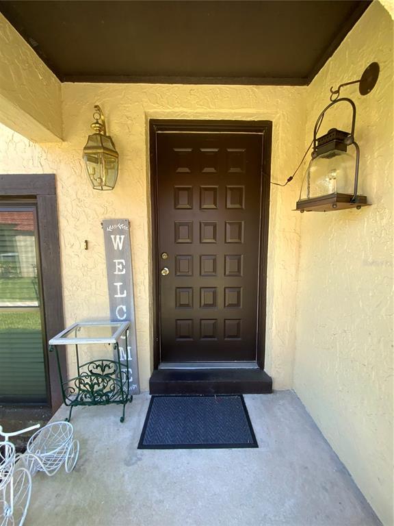 A front porch features a dark brown door, two wall-mounted lanterns, and a welcome sign — 517 HUNTER CIRCLE, KISSIMMEE, FL