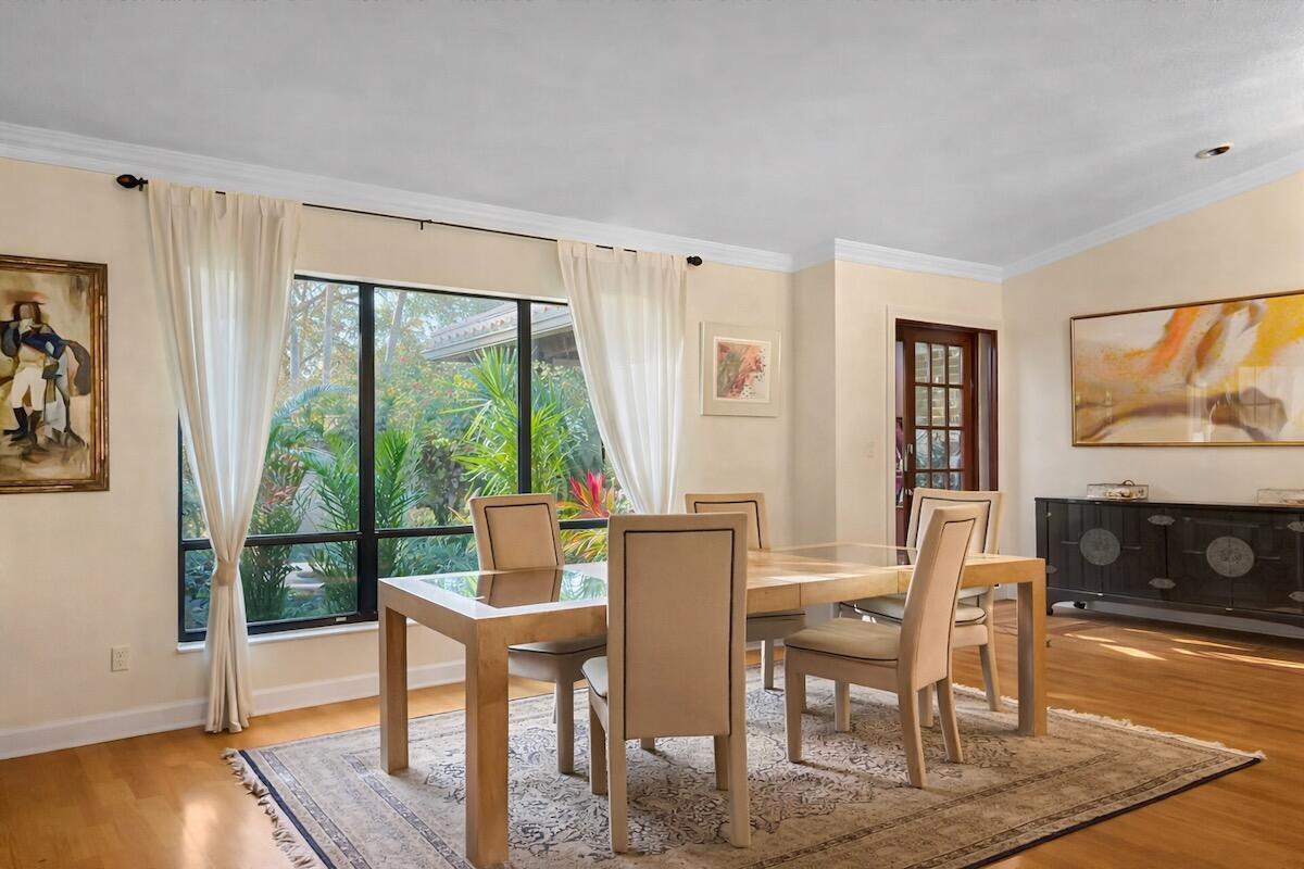 A dining room with a glass-top table, upholstered chairs, a rug, and a large window — 20952 Delagado Terrace, Boca Raton FL 33433, BOCA RATON, FL