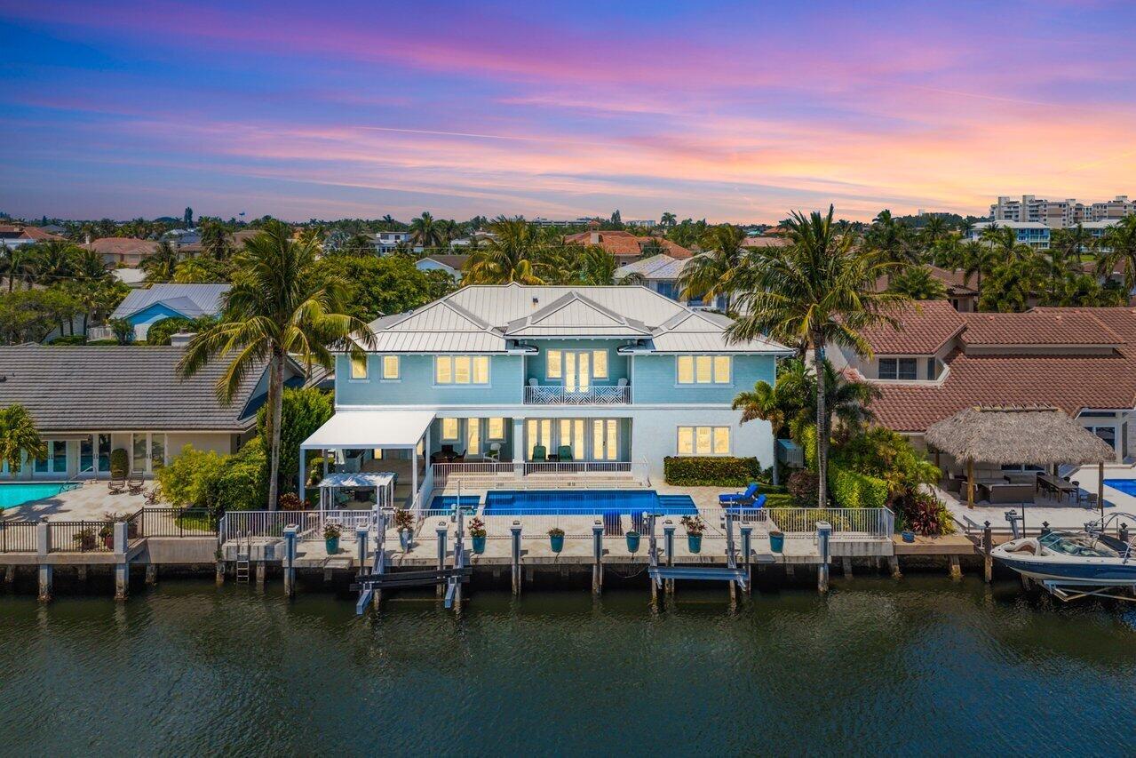 An aerial view of a blue waterfront house with a pool, dock, and boat lift — 960 Dogwood Drive, Delray Beach FL 33483, DELRAY BEACH, FL