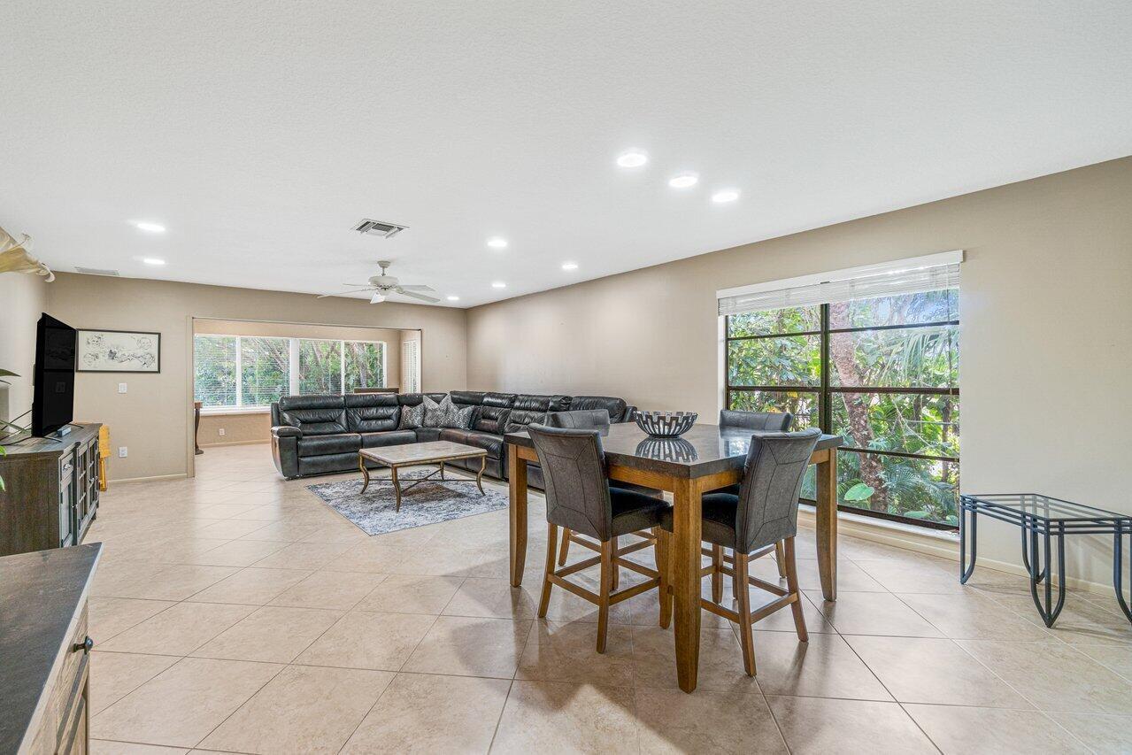 A spacious living and dining area with tile floors, a sectional sofa, and large windows — 22 Westgate Lane # 22h, Boynton Beach FL 33436, BOYNTON BEACH, FL