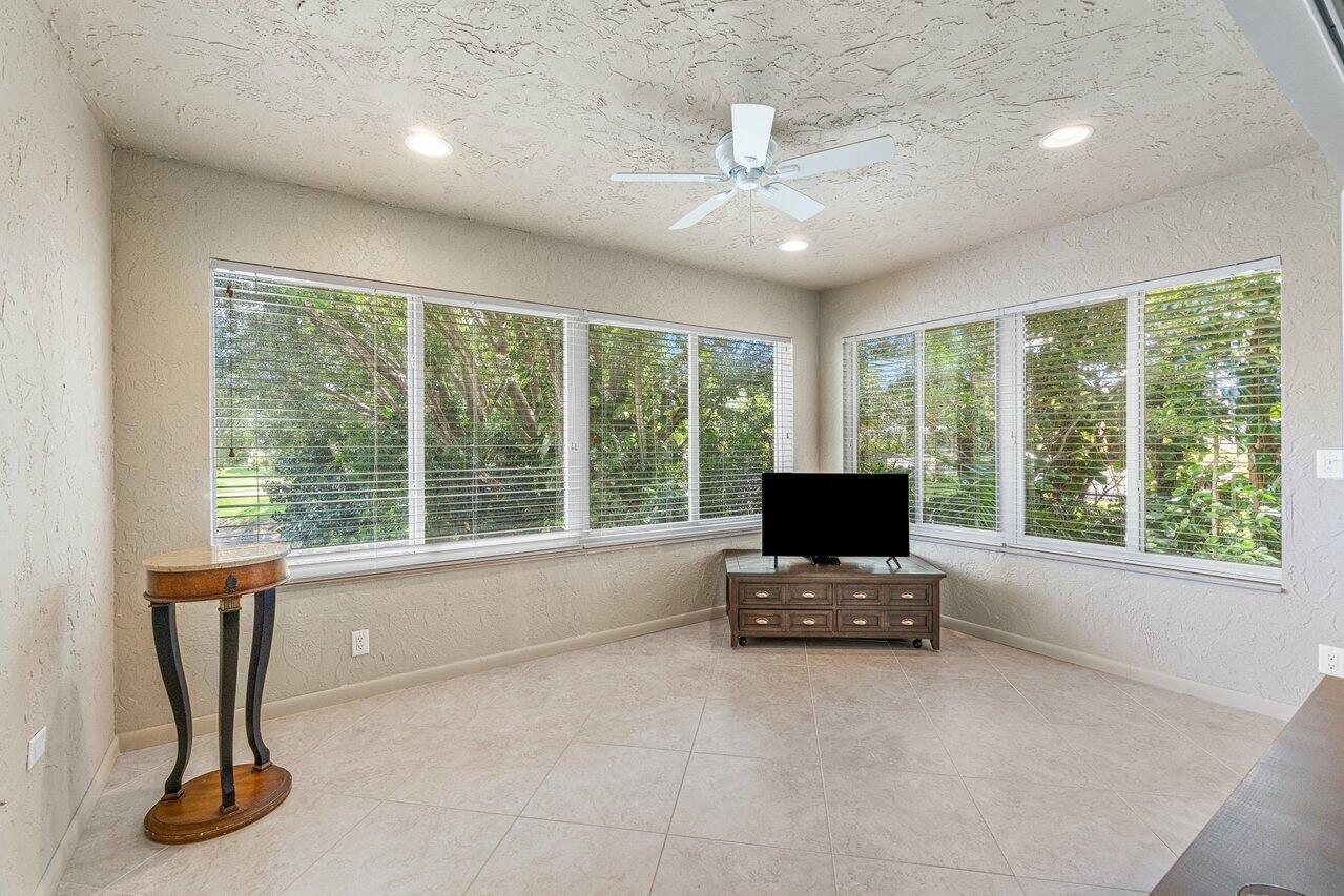 A sunroom with tile flooring, large windows with blinds, a ceiling fan, and neutral walls — 22 Westgate Lane # 22h, Boynton Beach FL 33436, BOYNTON BEACH, FL
