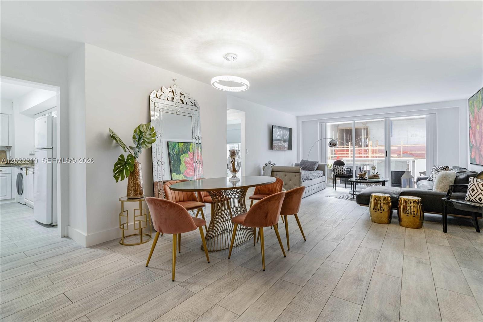 A dining area and living room feature light wood-look tile floors and modern furniture — 9195 NE Collins Ave # 1104, Surfside FL 33154, SURFSIDE, FL