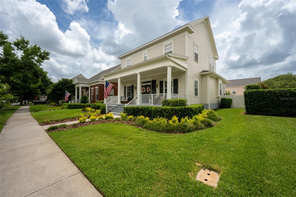 A two-story house with light gray siding, dark shutters, and a covered front porch — 712 TEAL AVENUE, CELEBRATION, FL