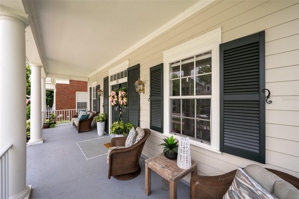 A two-story house with light siding and a front porch sits beside a sidewalk — 712 TEAL AVENUE, CELEBRATION, FL