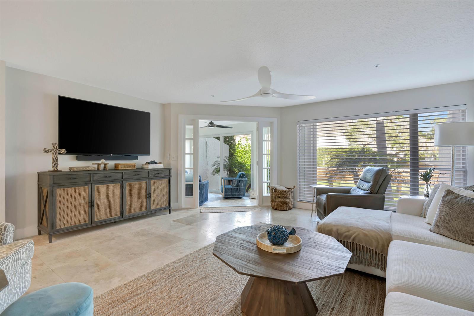 A living room features a television console, a sectional sofa, and a glass door entrance — 1000 N Us Highway 1 # 658, Jupiter FL 33477, JUPITER, FL