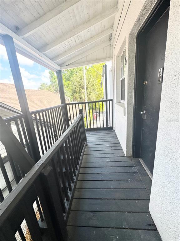 An exterior wooden walkway leads to a black door marked with the number six — 704 CORDOVA DRIVE UNIT 7, ORLANDO, FL