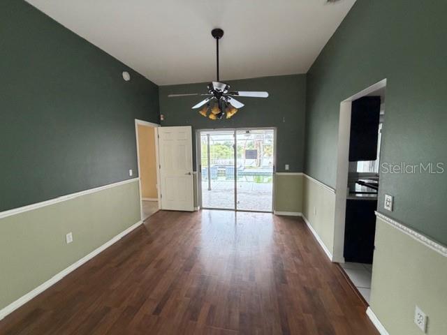 A living room features two-toned green walls, wood-look flooring, a ceiling fan, and sliding glass doors — 1235 ODONIEL LOOP S, LAKELAND, FL