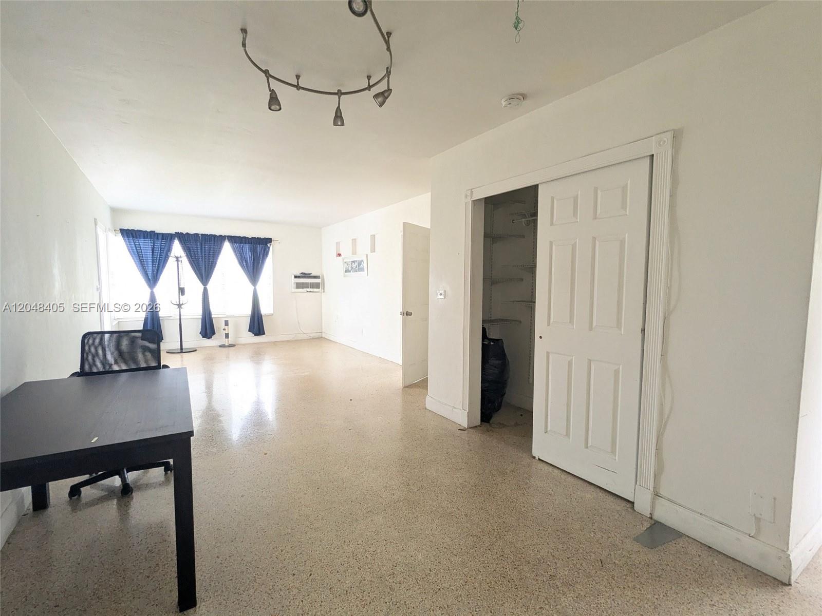A room with white walls, terrazzo flooring, a ceiling track light, and a closet — 7805 Crespi Blvd # 1, Miami Beach FL 33141, MIAMI BEACH, FL