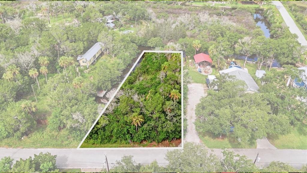 An aerial view shows a wooded, trapezoidal vacant lot situated between two residential properties — 1550 S WALLACE POINT, CRYSTAL RIVER, FL