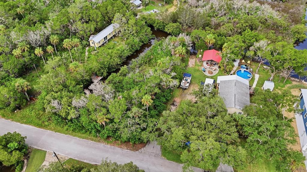 An aerial view shows a house with a pool, a boat, and a detached structure — 1550 S WALLACE POINT, CRYSTAL RIVER, FL