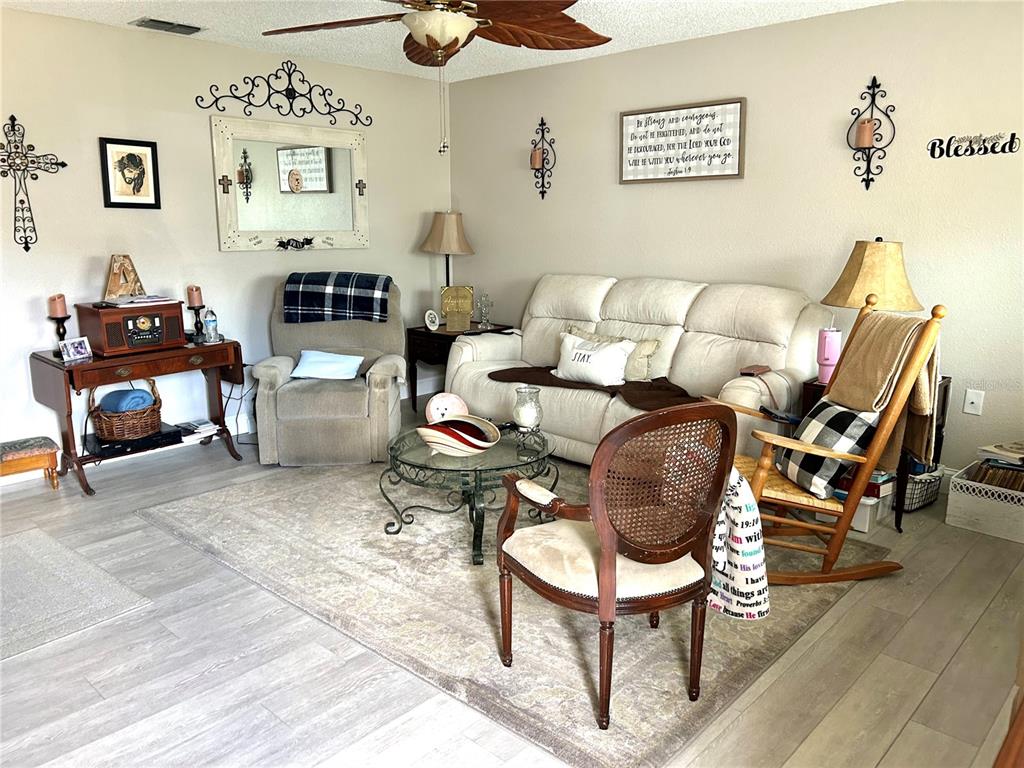 A living room features a white sofa, a recliner, a rocking chair, and a coffee table — 11909 BAYONET LANE UNIT 113A, NEW PORT RICHEY, FL