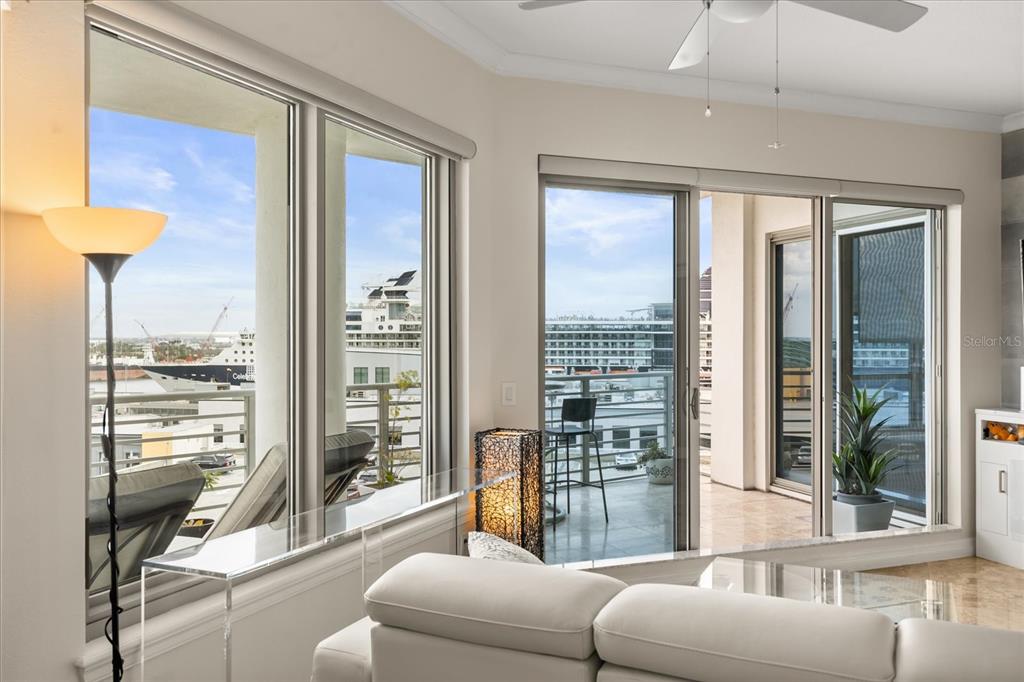 A living room with a white sofa, large windows, and a balcony overlooking a harbor — 1209 E CUMBERLAND AVENUE UNIT 807, TAMPA, FL