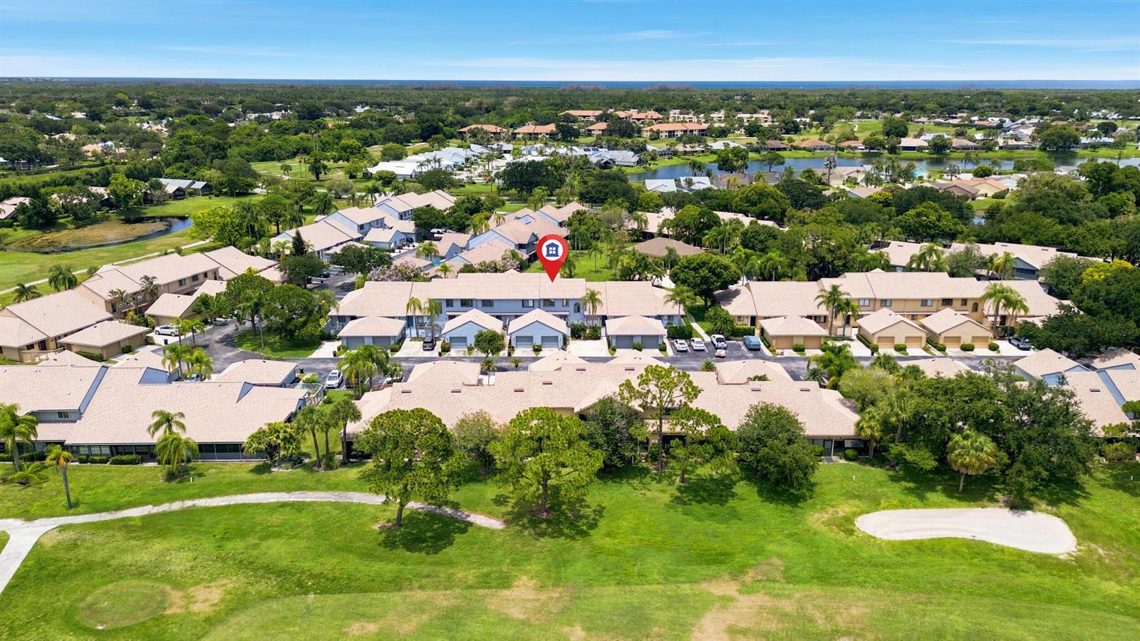 An aerial view shows a multi-unit residential complex situated next to a golf course — 6167 SE Georgetown Place, Hobe Sound FL 33455, HOBE SOUND, FL