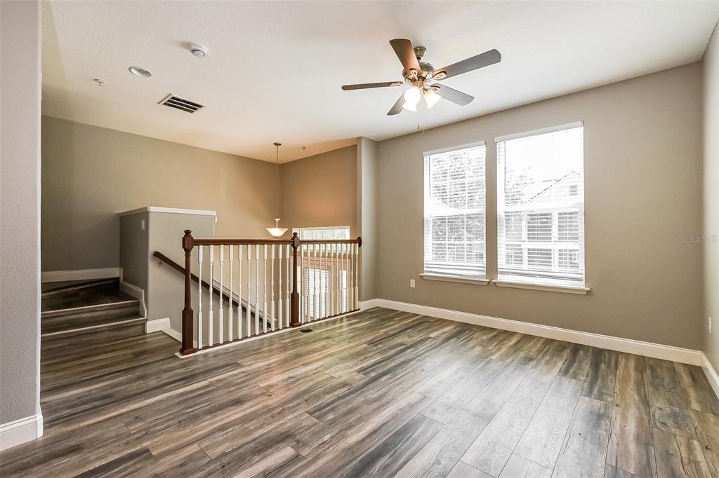 An upstairs landing features wood-look flooring, a ceiling fan, and a wooden staircase railing — 1384 MILL STREAM LANE, WINTER SPRINGS, FL