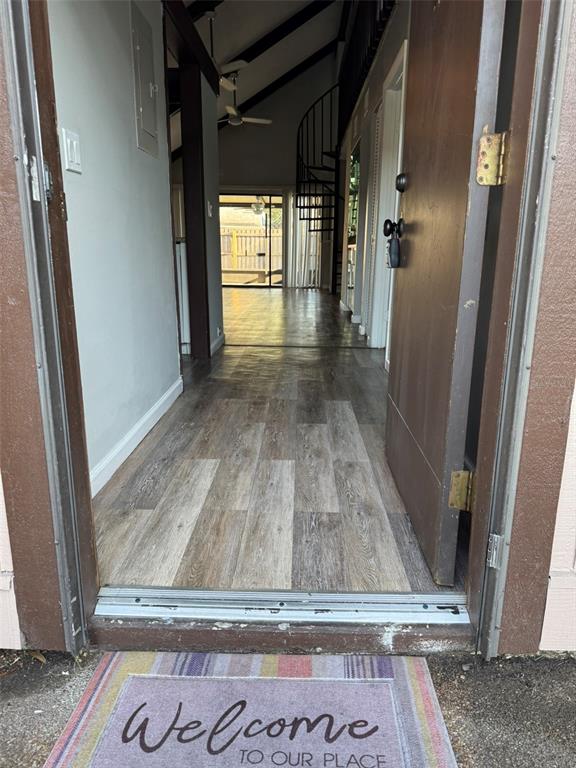 An open doorway reveals a hallway with wood-look flooring, a spiral staircase, and vaulted ceilings — 4008 MURIEL PLACE UNIT 1, TAMPA, FL