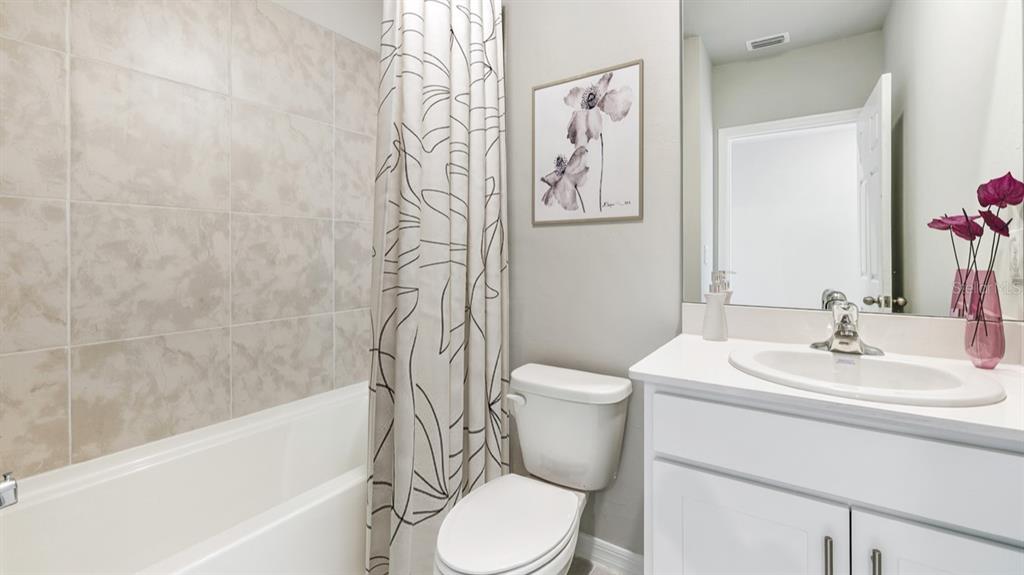 A bathroom features a white vanity, a toilet, and a bathtub with tiled walls — 16435 BECASSE DRIVE, PUNTA GORDA, FL