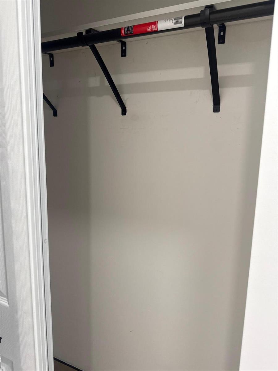 A closet interior featuring a black metal rod and support brackets mounted on white walls — 1235 Normandy Drive # 10, Miami Beach FL 33141, MIAMI BEACH, FL