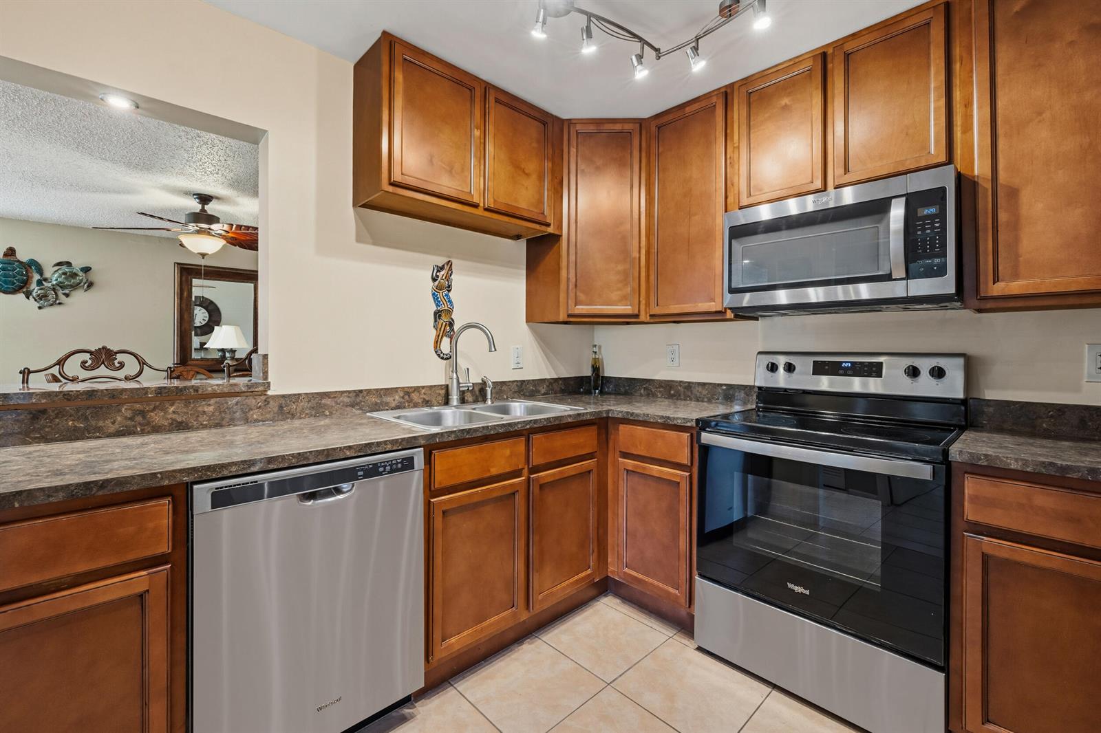 A kitchen with wood cabinets, stainless steel appliances, and a dark laminate countertop — 2050 Oleander Boulevard # 106, Fort Pierce FL 34950, FORT PIERCE, FL