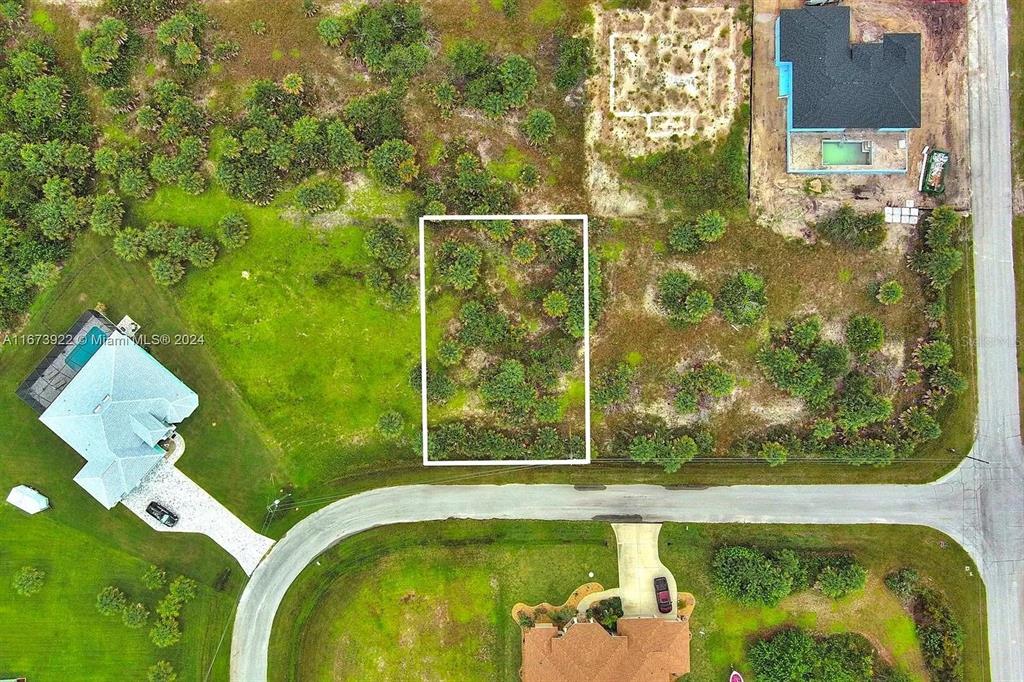 An aerial view shows a vacant rectangular lot surrounded by trees and residential homes — 145 LOFTIN STREET, PORT CHARLOTTE, FL