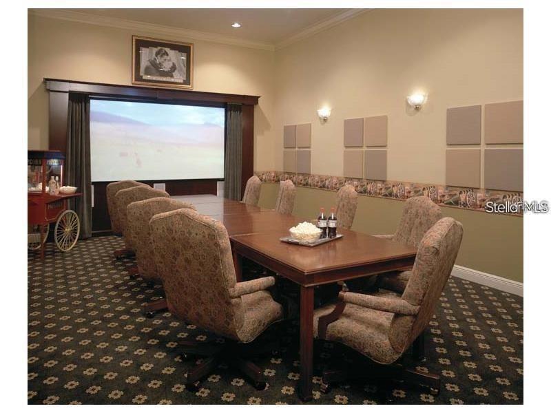 A home theater room features a large projection screen, a long conference table, and chairs — 10019 COURTNEY PALMS BOULEVARD UNIT 303, TAMPA, FL