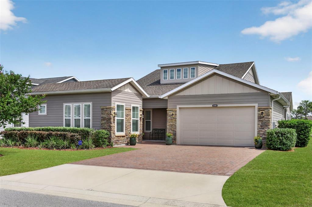 A single-story house with a brick driveway, stone accents, and a two-car garage — 5448 NW 35TH LANE ROAD, OCALA, FL