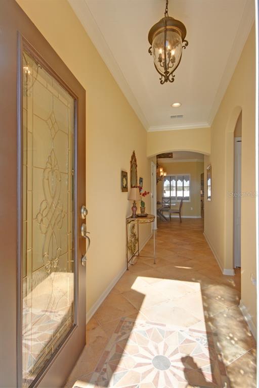 An entryway with a decorative glass door, tile flooring, and a hanging lantern light fixture — 15825 DURANGO CIRCLE, BROOKSVILLE, FL