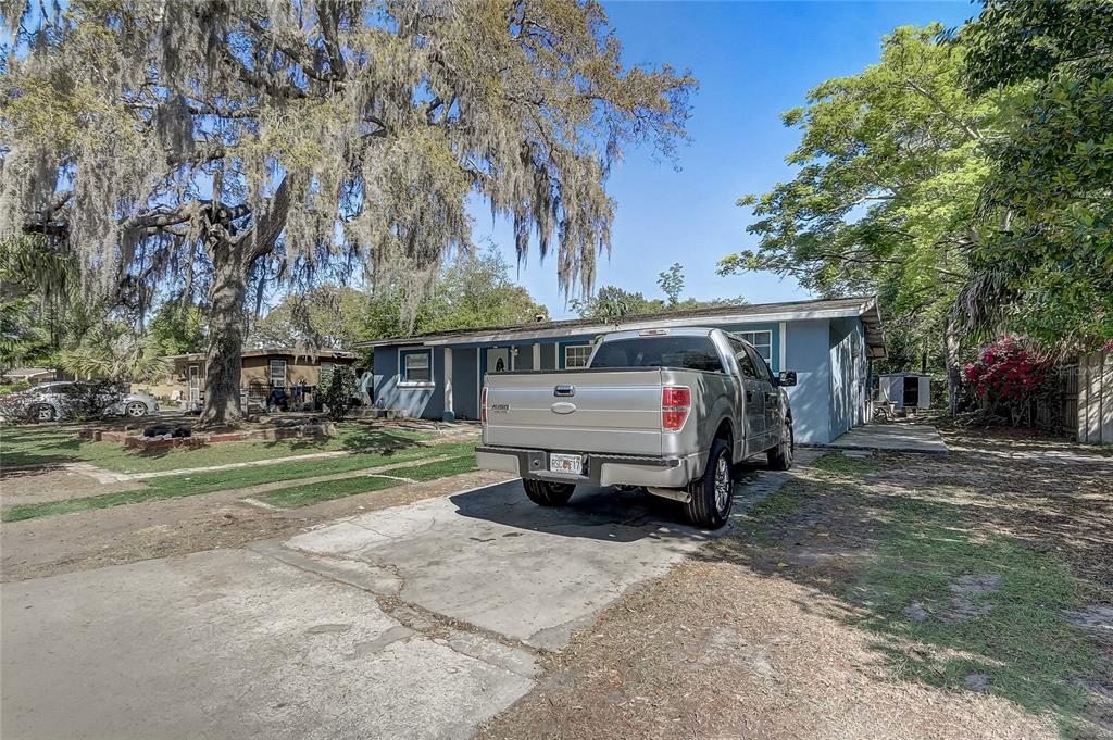 A silver pickup truck is parked on a concrete driveway in front of a blue house — 243 W MARTIN STREET, APOPKA, FL